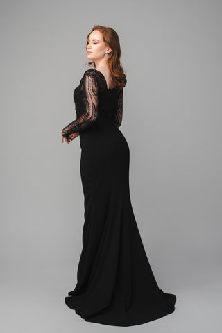 The Elea Dresses Alexia dress features a diagonally cut back, creating a sleek and modern look. It flows into a small, elegant train that adds a touch of grace and drama, enhancing the overall sophistication of the design.