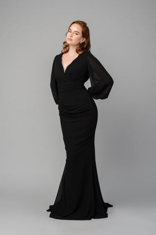 The Elea dresses Clara dress in black features a pleated V-neckline and is tailored around the waist. It is a fitted dress with a small train. The sleeves are balloon-styled, and the cuffs feature detailed buttons.