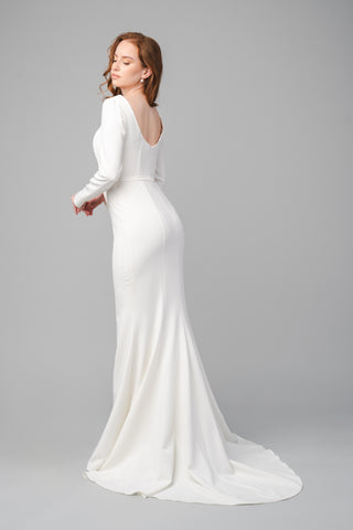 The Elea Dresses Louana dress in white features a rounded back and a train.